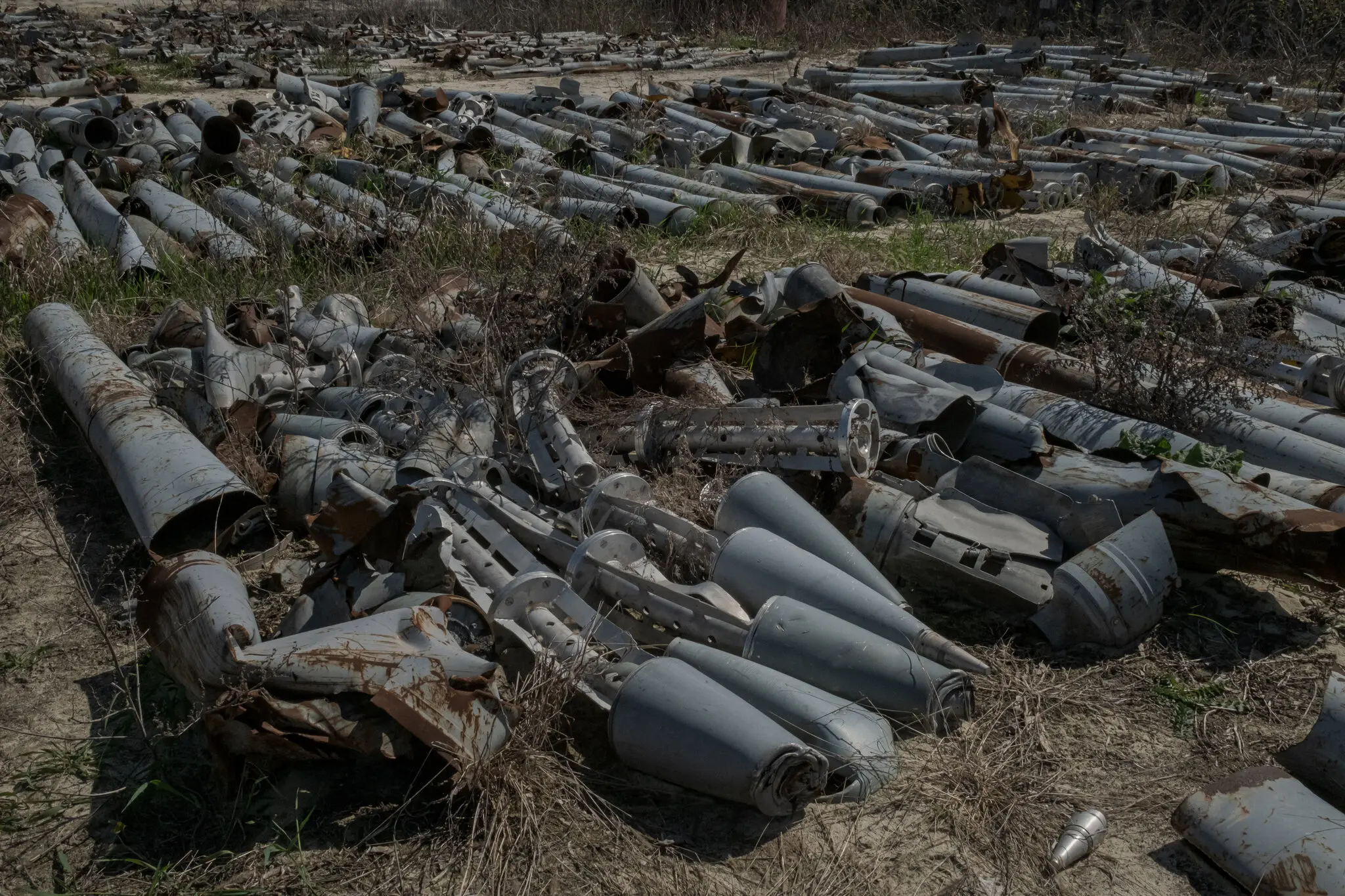 Тисячі частин артилерійських снарядів, уламків ракет і некерованих реактивних снарядів, які з початку війни влучили в будівлі по всьому Харкову, на промисловому полі 17 квітня.